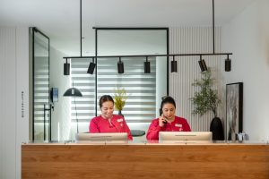 Two friendly receptionists at the front desk of Najat Hazimeh Clinic, Dubai women’s health center