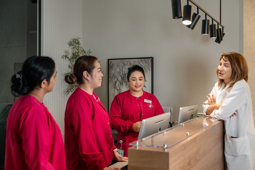 Welcoming reception team assisting a female patient at Najat Hazimeh Clinic, Dubai women’s health center